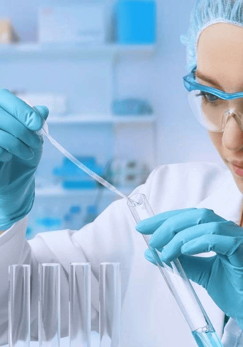 A lab technician adding solution to a test tube